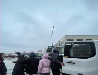 ICDI distributing Essential goods from a van with immigrants waiting in line.